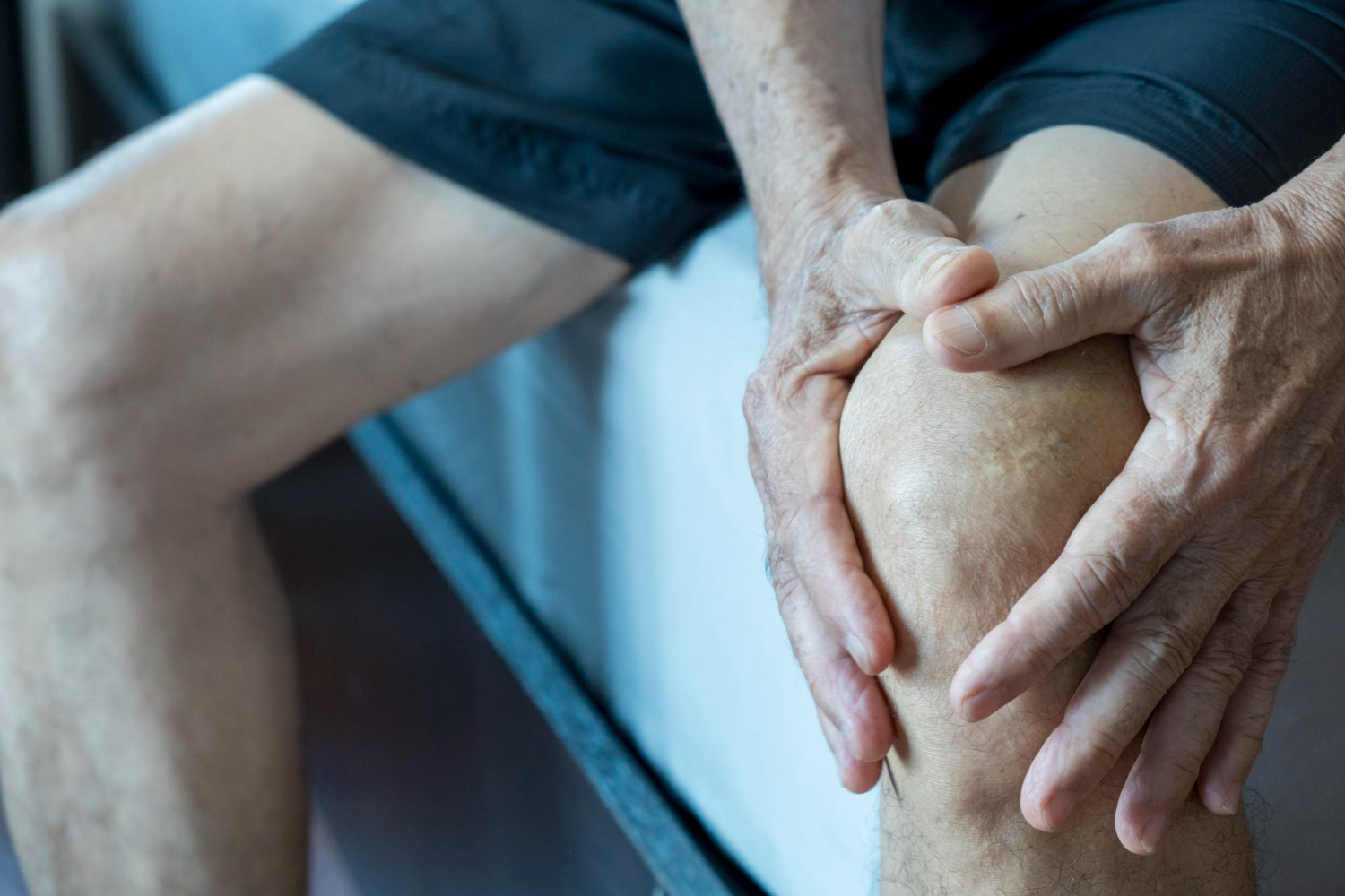 closeup-hand-elderly-asian-man-holding-his-knees-with-pain-bones-joints-man-suffering-sitting-sofa-mature-man-massaging-his-painful-knee-man-suffering-home
